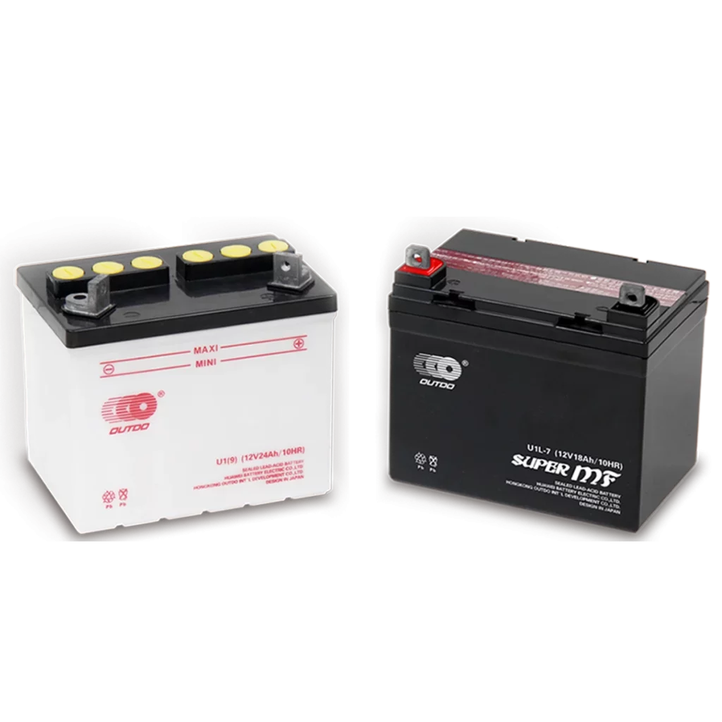 Two motorcycle batteries, one white and one black, are shown side-by-side. The white battery has a black top with yellow terminals and is labeled "U1/9 (12V24Ah/10HR)". The black battery has red and black accents and is labeled "U1L-7 (12V18Ah/10HR) SUPER MF". The brand name "OUTDO" is visible on both batteries.